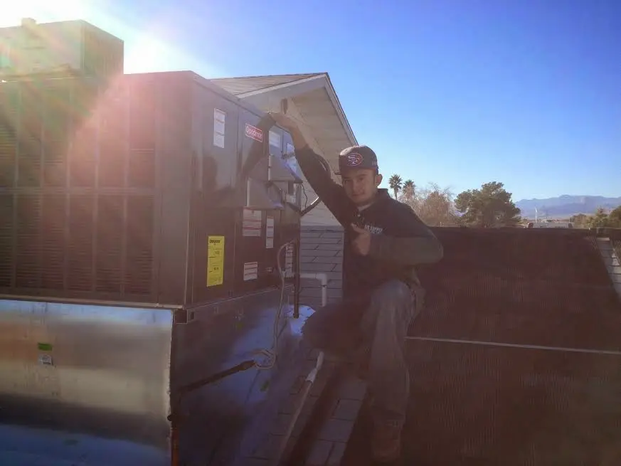 HVAC technician performing AC Tune-Up on a rooftop unit in Hyde Park